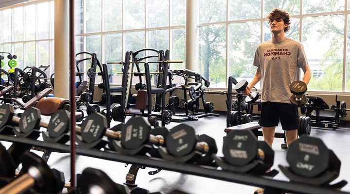 a student lifts hand weights