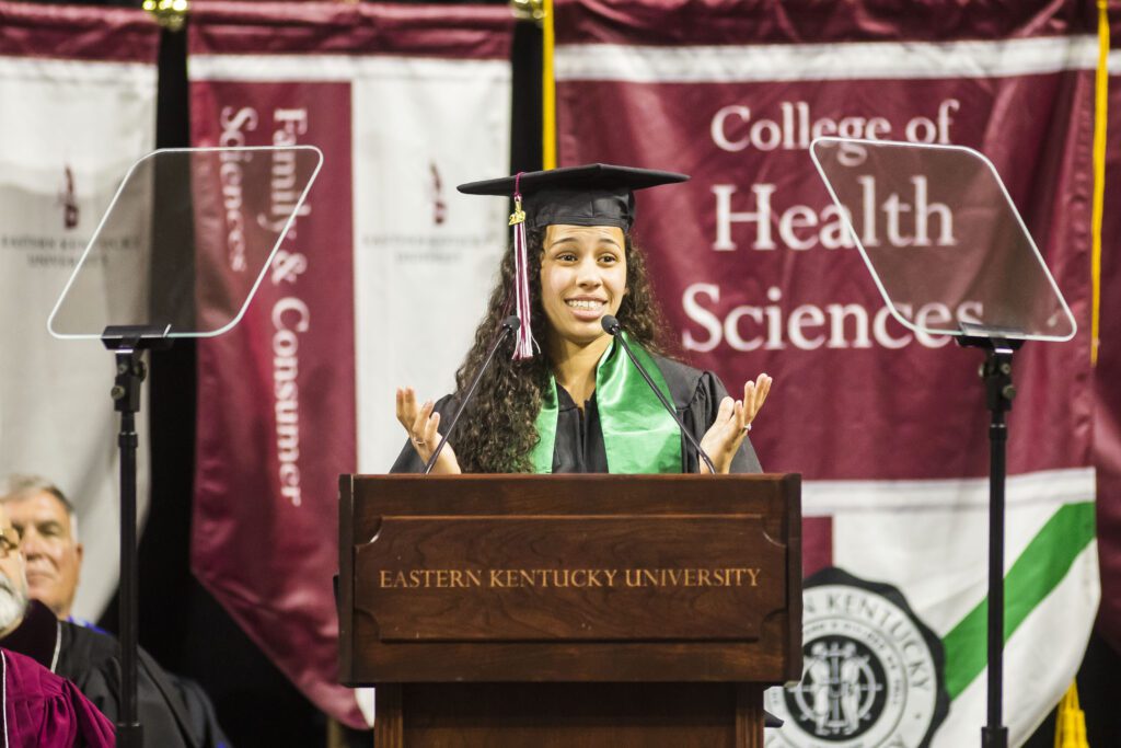 a student speaks at a podium during commencement