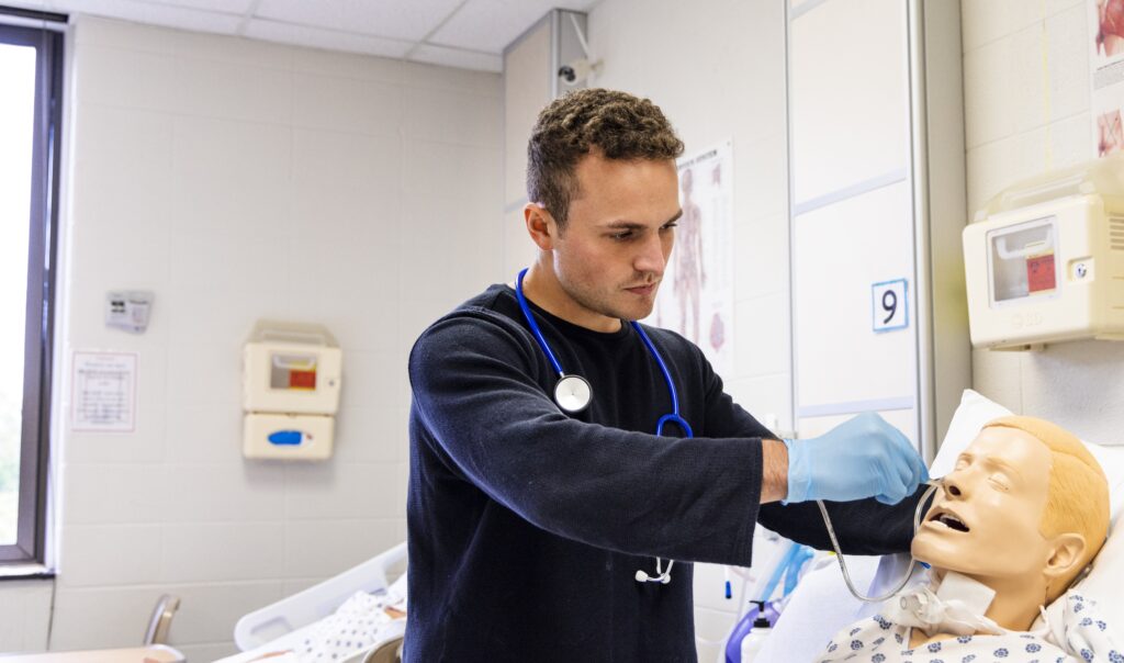 a student nurse checks a model of a patient