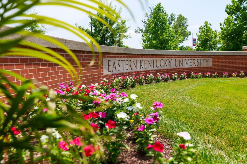 Eastern Kentucky University brick wall with university name and flowers in the foreground