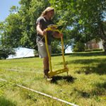 A student conducts an electrical resistivity survey in the field.