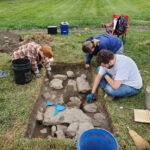 Students excavating a limestone wall foundation