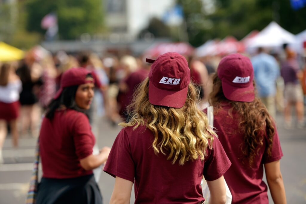 students wearing backwards ball caps with EKU logos