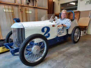 Dr. Russell Williamson seated in a white and blue cyclekart