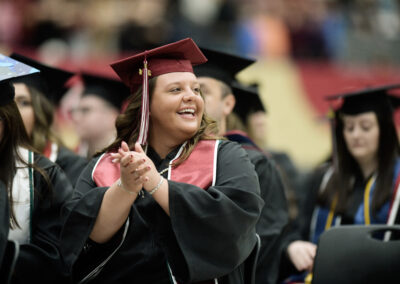 a student claps during the commencement ceremony
