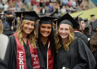three students pose together during the commencement ceremony