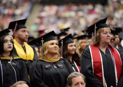 students stand in their row during the commencement ceremony