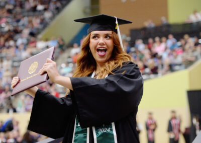 a student celebrates with their diploma cover during the commencement ceremony