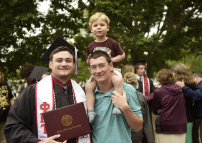 a student poses with their family after commencement