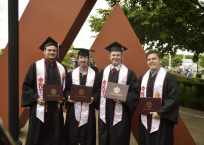 four students pose together after commencement