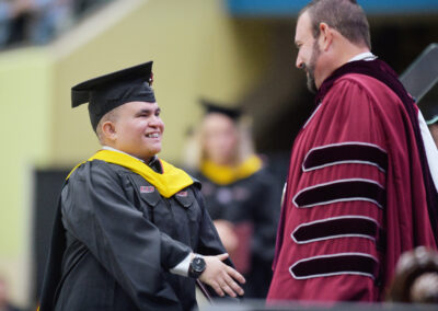 President McFaddin hands a student their diploma