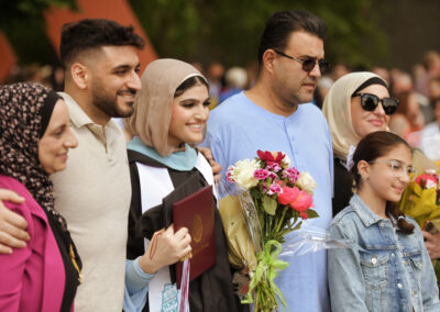 a student poses with their family after the commencement ceremony