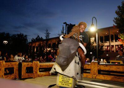 a student rides a bucking bull simulator