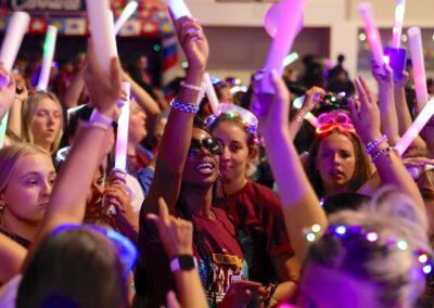 students wave colored lights during the Big E Bash