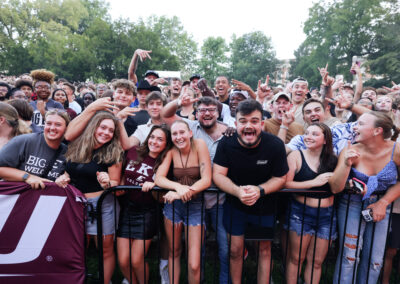 Large group of male and female EKU students celebrate and smile awaiting the start of the outdoor Flo Rida concert