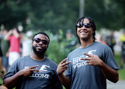 Two male EKU students wearing Big E Welcome t-shirts smile and pose as the wait for the Flo Rida outdoor concert to begin