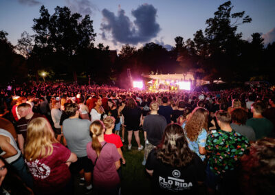 A view from the back of the crowd at the outdoor night time Flo Rida concert of the stage