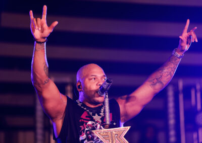 Flo Rida sings with hands up at outdoor concert