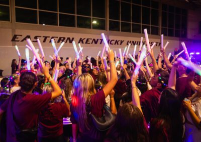 a crowd of students waves their colored lights