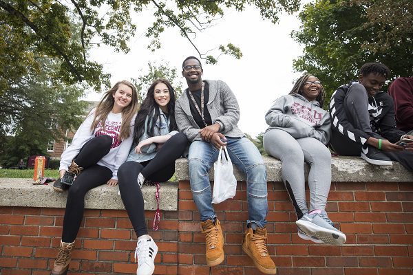 Students sitting on a wall at EKU.