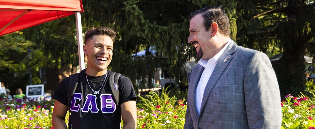 Christian Bustos and EKU President Dr. David McFaddin laugh outside at a campus event.