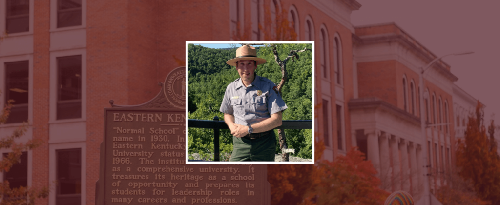 EKU graduate, Park Ranger Jordan Gibbs, stands in uniform in front of a scenic overlook.