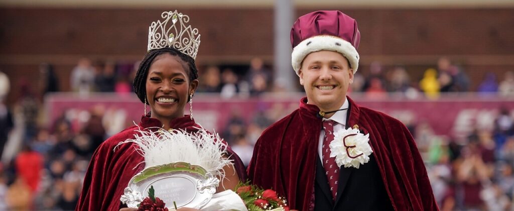 EKU's Homecoming Queen and King, Ainye Rogrs and Carson England smile after being crowned on the football field.