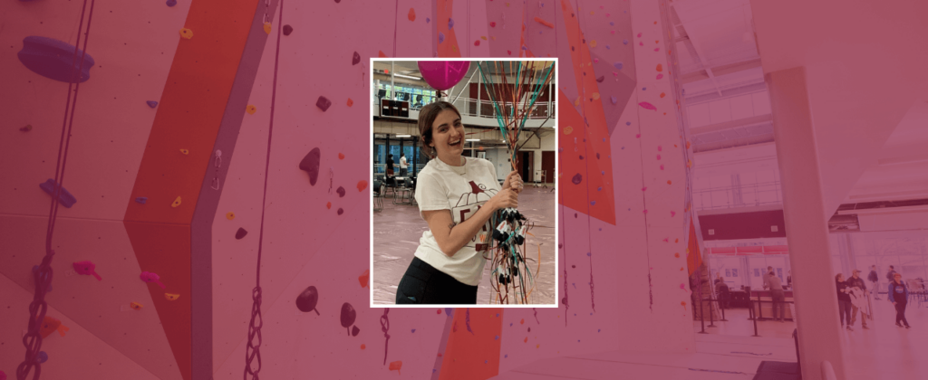 EKU student McCarney Derington holds a large bunch of balloons in the Campus Recreation Center and smiles.