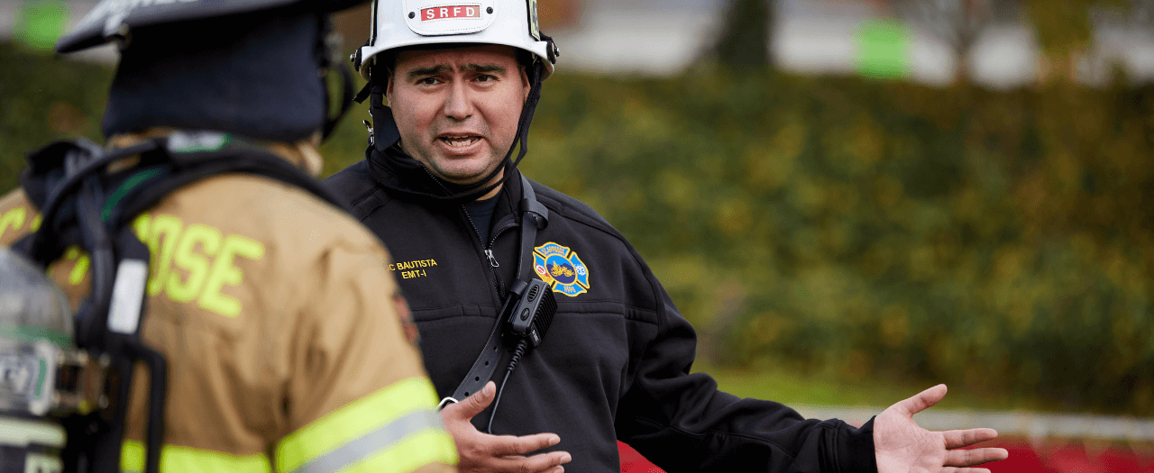 EKU graduate Miguel Bautista works on the job with a firefighter.