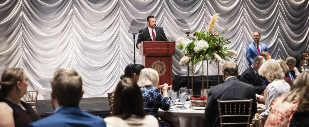 EKU President David McFaddin stands at the podium and addresses EKU faculty and staff at the Excellence Awards ceremony.