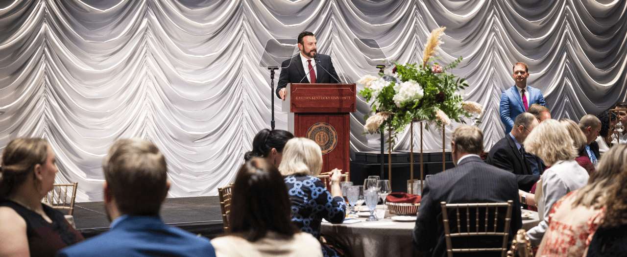 EKU President David McFaddin stands at the podium and addresses EKU faculty and staff at the Excellence Awards ceremony.