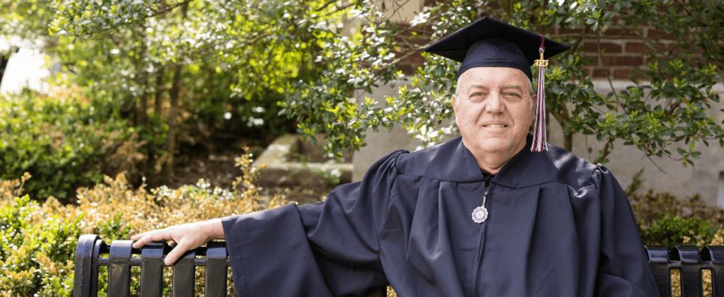 EKU graduate Randy Carpenter sits outside at commencement.