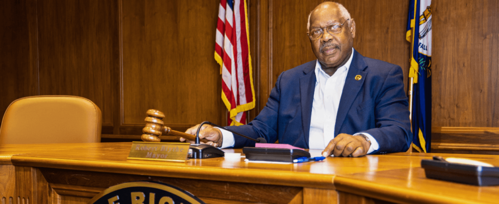 Richmond, Ky. mayor and reverend Robert Blythe sits at his desk with gavel in hand.