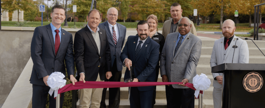 Richmond and Berea mayors, and Congressman Andy Barr are among the crowd with EKU President David McFaddin as he cuts the marron ribbon with giant scissors.