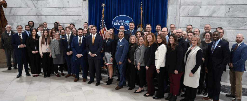 A large group of EKU faculty and staff stand with Governor Andy Beshear in the capital rotunda.