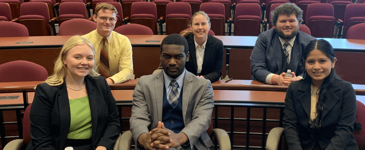 Six EKU mock trial students sit in a courtroom after competition.