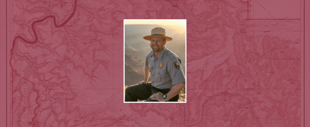 EKU graduate Nate Powell in uniform sits at an overlook at sunrise.