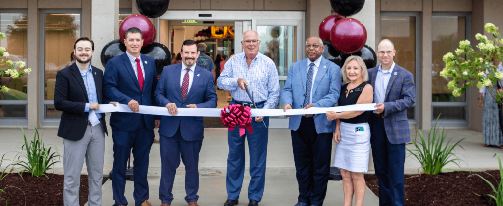 EKU Board of Regents members and Richmond Mayor Blythe join President David McFaddin and hold the ribbon at the ribbon cutting ceremony.