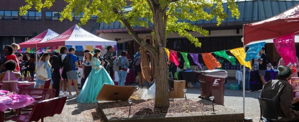 The Powell Plaza courtyard bustles with bright colors and decorations and outfits as students celebrate Hispanic heritage.