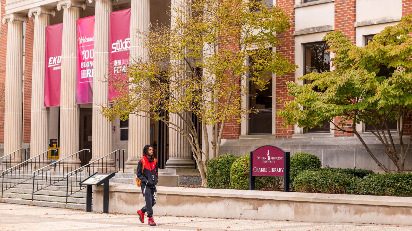 a student walks past the front entrance of Crabbe Library