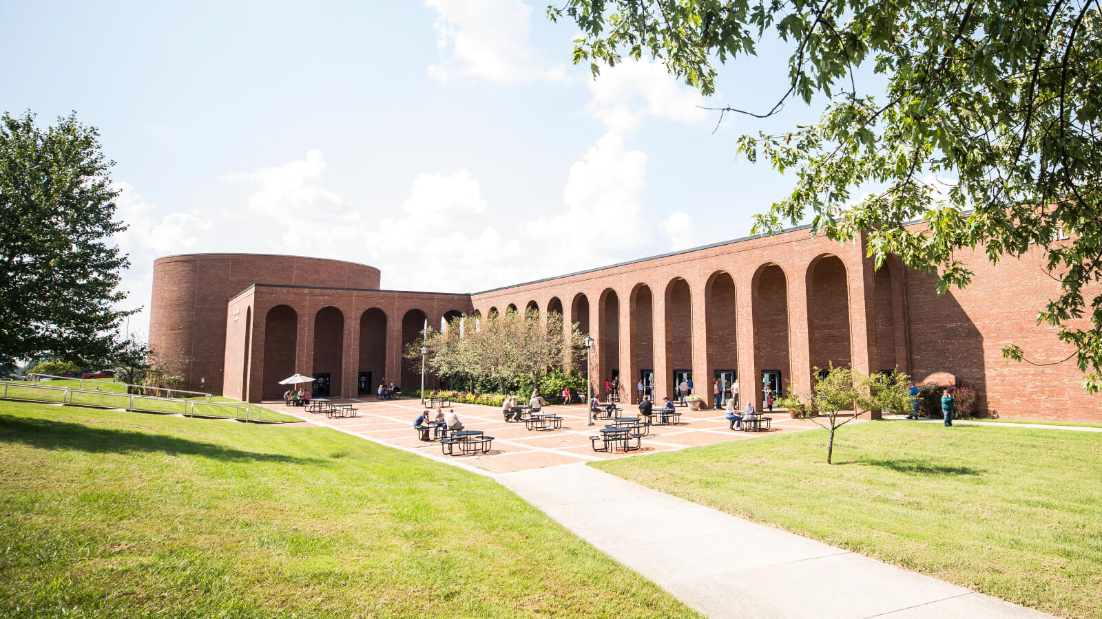 a view of the Perkins Building courtyard with students sitting at tables