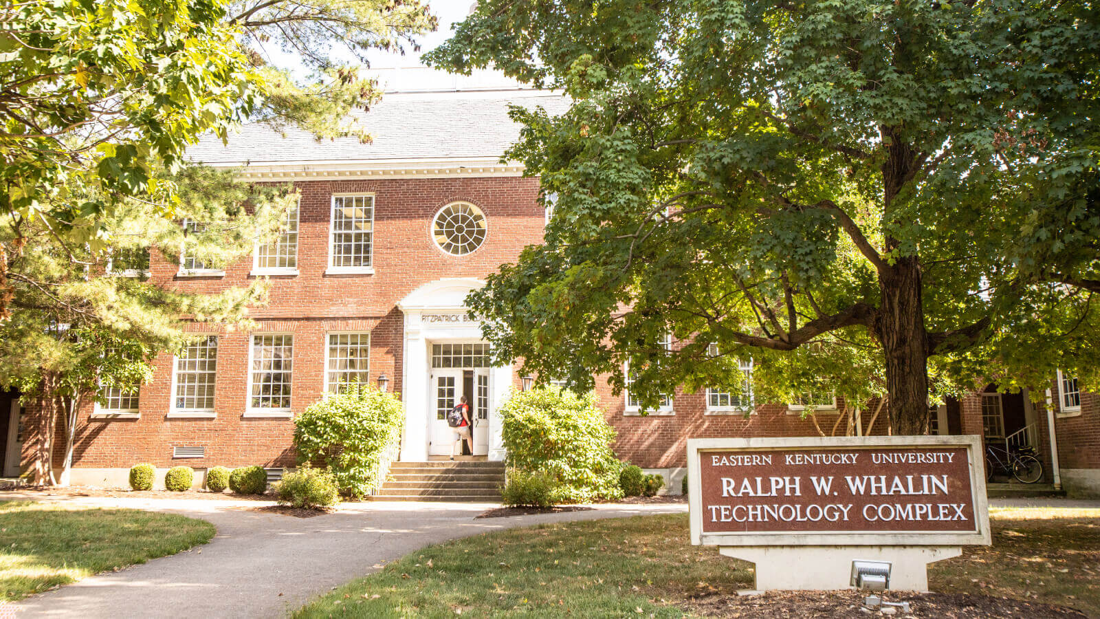 Front facing view of the Whalin Complex, surrounded by trees, on EKU's campus in summer.