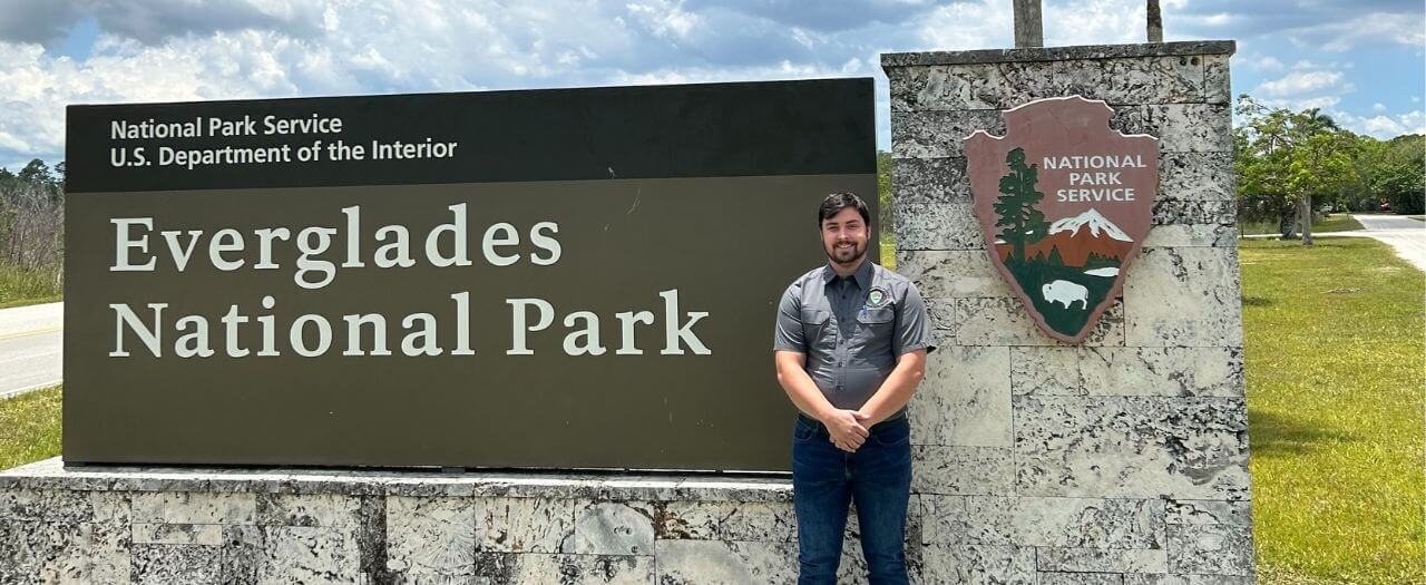 EKU alum, Kyle Januska, stands in front of the sign for Everglades National Park