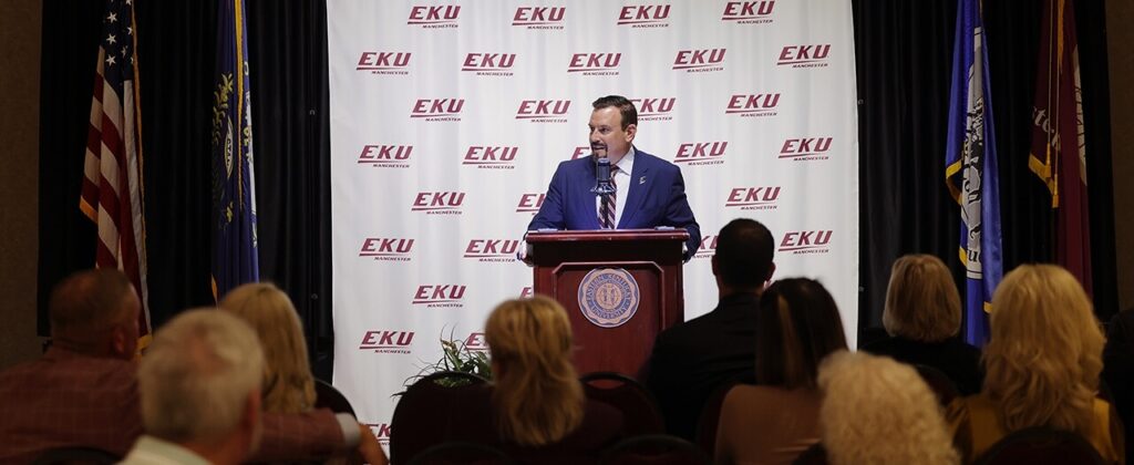 EKU President David McFaddin speaks from a podium in front of an EKU backdrop at the EKU Manchester Scholarship reception.