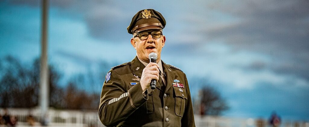 Gen. James Rainey, in his Army uniform and holding a microphone, speaks to the crowd with outside at EKU's Military Appreciation Day.