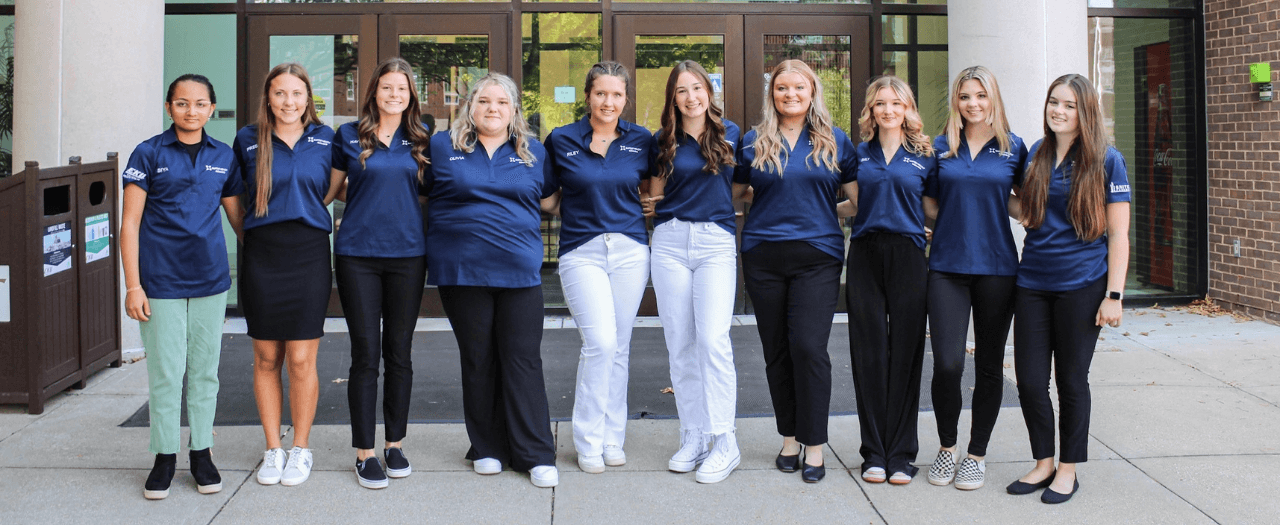 A group of local high school girls stand together outside the Dizney Building on campus after they are inducted into the Medical Explorers Academy