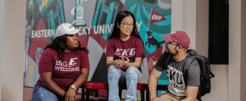 group of EKU students visitng and laughing outside on a picnic table