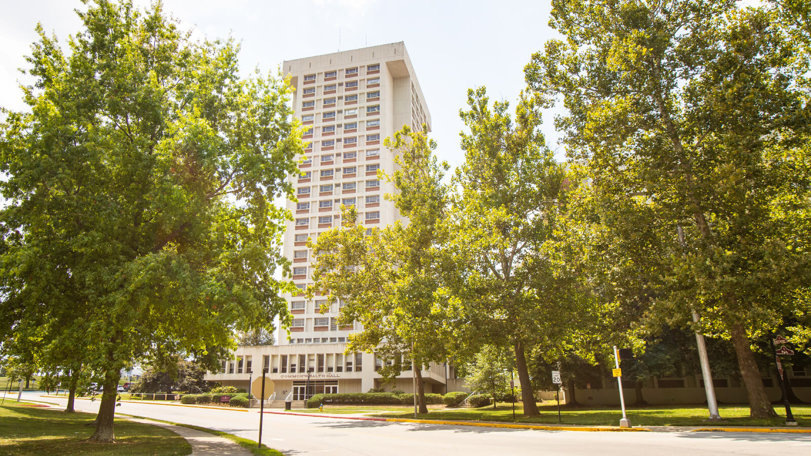 Front view of Commonwealth Hall framed by green trees