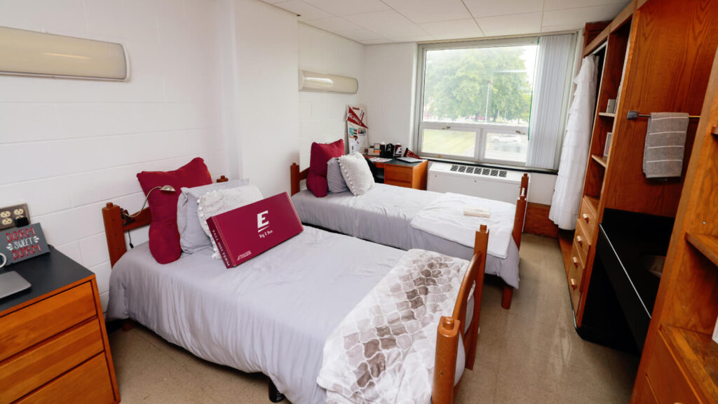 a shared room in Clay Hall with two desks and two beds and windows and closets and cabinets and a sink