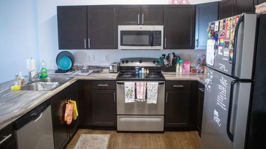 the kitchen of a Grand Campus apartment with a dishwasher and stove and microwave and refrigerator